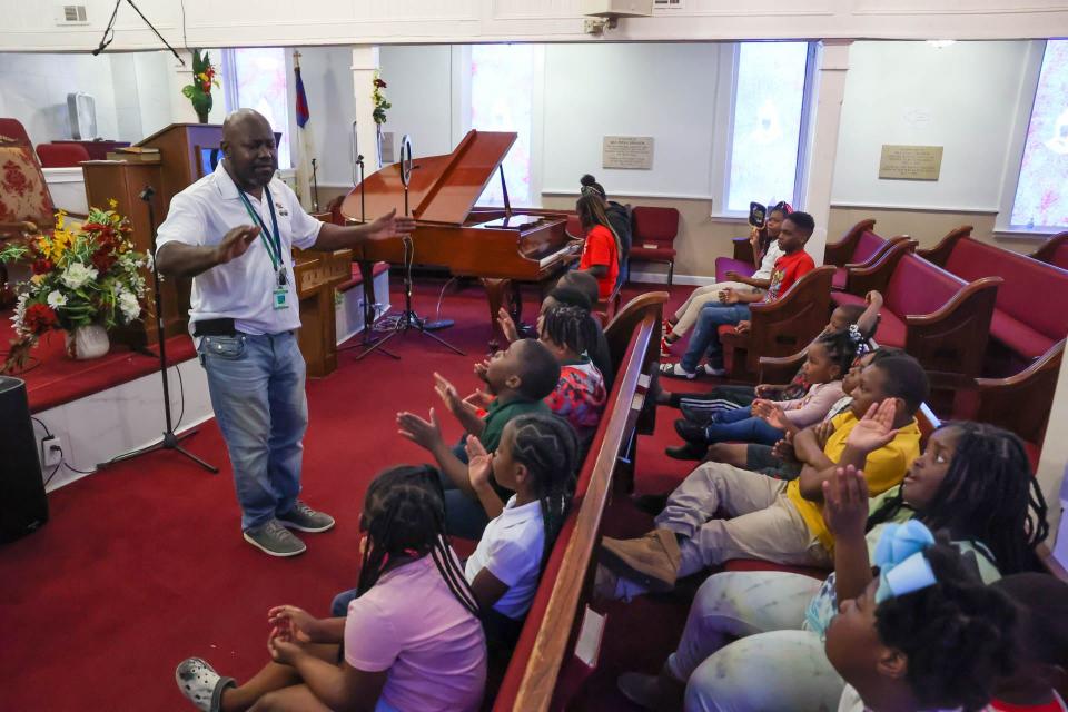 James Kirk works with students as they learn a gospel song at Central Missionary Baptist Church in Hitch Village.