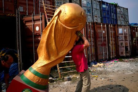 Workers work on a FIFA World Cup trophy replica at a small factory in the outskirts of Shanghai, China May 15, 2018. REUTERS/Aly Song/Files