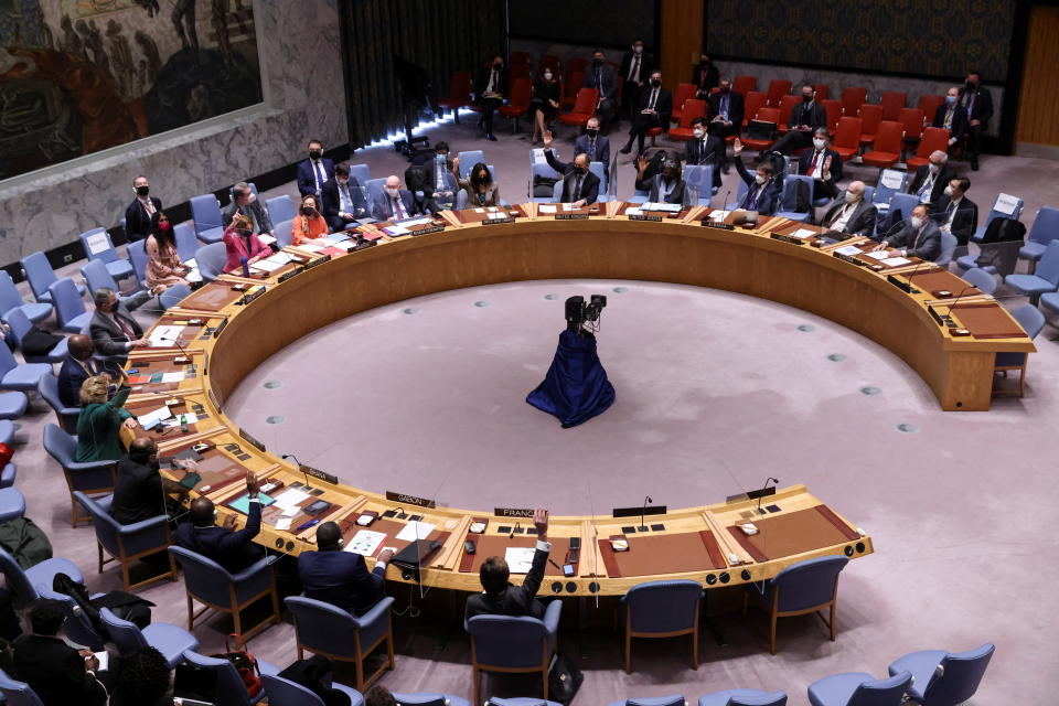 A general view from above of U.N. members seated at a table arced to almost form a complete circle.