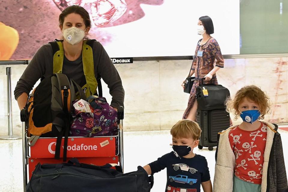 Passengers arrive at Sydney's international airport wearing face masks.