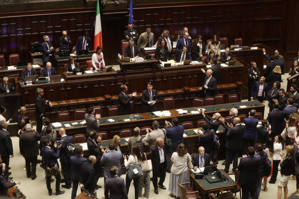 Italian Premier Giuseppe Conte, background center, acknowledges the applause at the end of a confidence vote at the Lower Chamber in Rome, Monday, Sept. 9, 2019. Conte is pitching for support in Parliament for his new left-leaning coalition ahead of crucial confidence votes. (AP Photo/Gregorio Borgia)