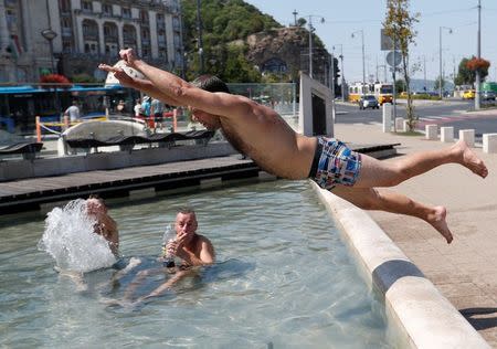 A man jumps into a fountain in Budapest, Hungary, August 4, 2017. REUTERS/Laszlo Balogh