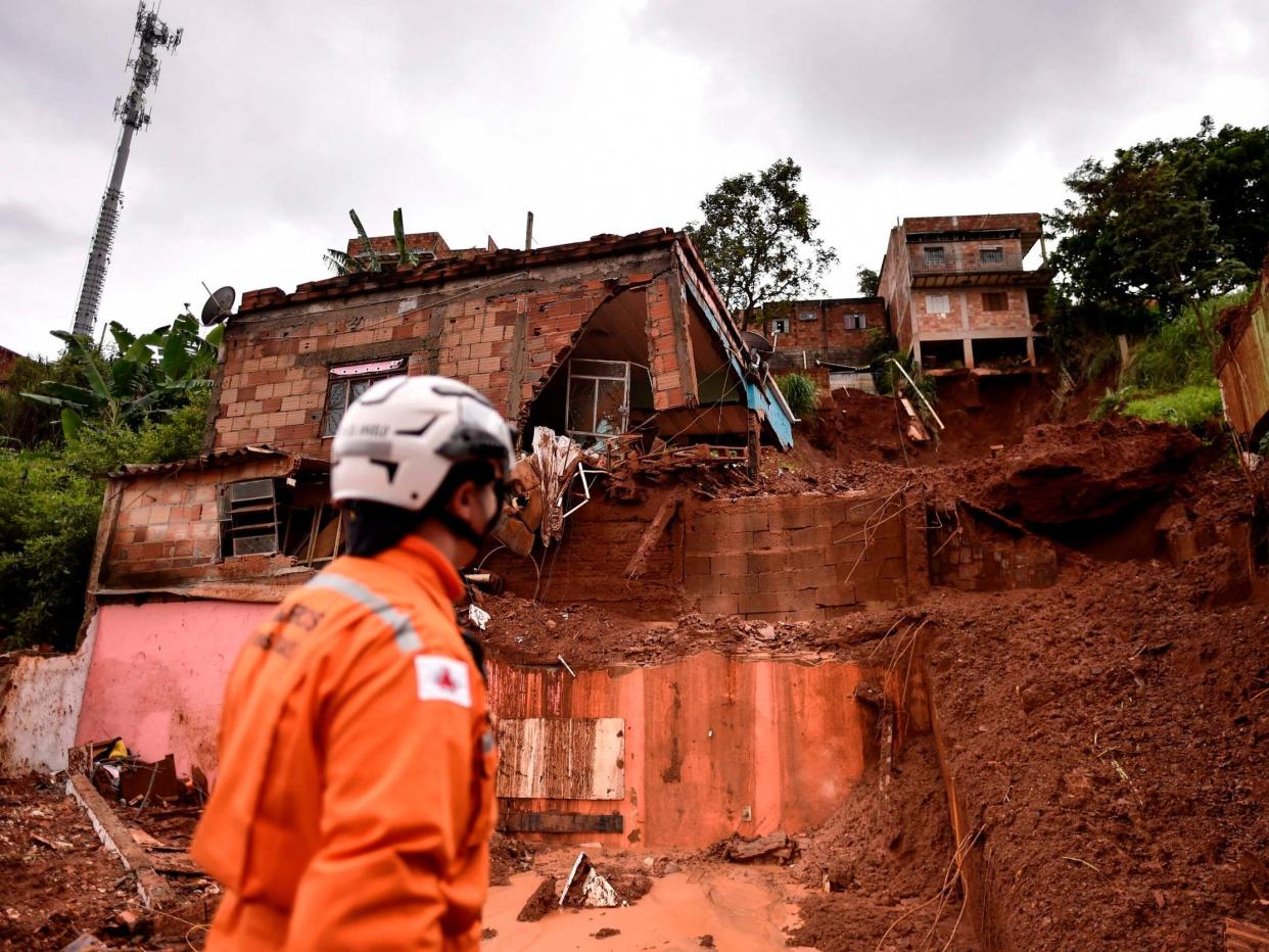 A firefighter looks at the site of a landslide in Belo Horizonte: AFP via Getty Images