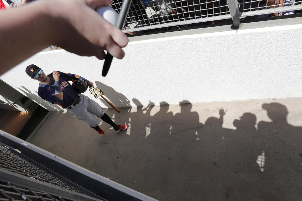 Houston Astros' Miguelangel Sierra walks to the field as fans seek autographs before a spring training baseball game against the Boston Red Sox, Thursday, March 5, 2020, in Fort Myers, Fla. (AP Photo/Elise Amendola)