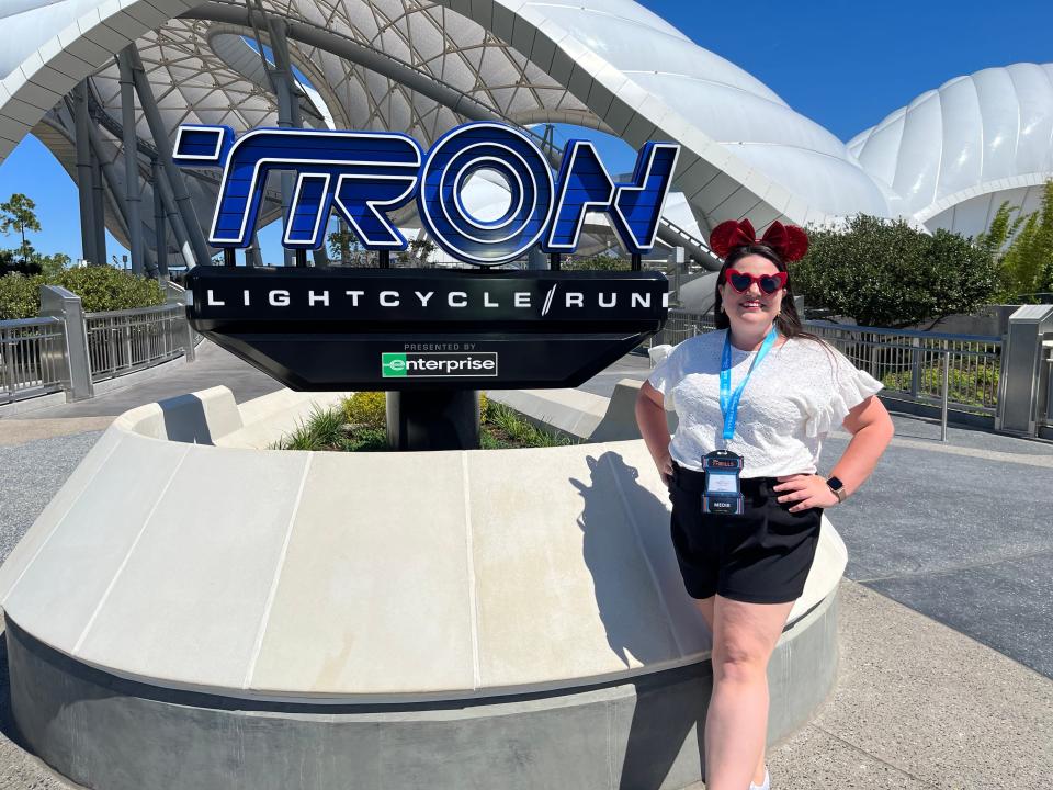 megan posing with the tron sign outside the magic kingdom roller coaster