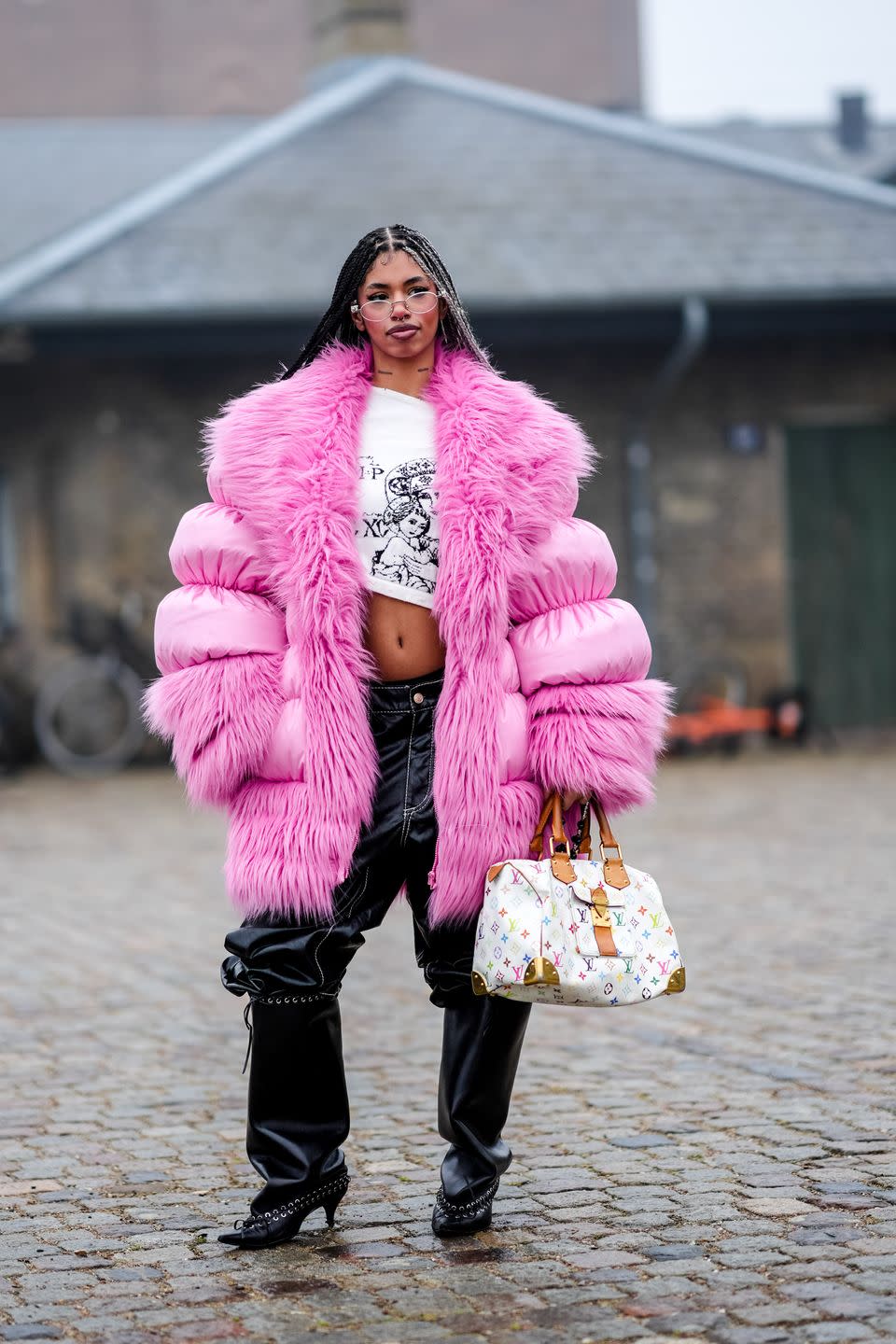 copenhagen, denmark january 30 a guest wears sunglasses, a white asymmetric crop top, a pink oversized winter puffer jacket , black leather pants , a white vuitton bag, kitten hels pointed shoes, outside rolf ekroth, during the copenhagen fashion week aw24 on january 30, 2024 in copenhagen, denmark photo by edward berthelotgetty images