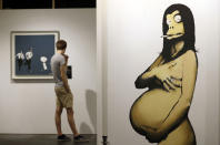 <p>A visitor walks past the giant painting ‘Pregnant Monkey’ (R) by British Banksy during the exhibition ‘The Art of Banksy’ in Berlin, Germany on June 20, 2017. (Felipe Trueba/EPA/REX/Shutterstock) </p>