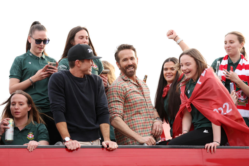 WREXHAM, WALES - MAY 02: Ryan Reynolds, Co-Owner of Wrexham, and Rob McElhenney, Co-Owner of Wrexham, celebrate with players of Wrexham Men and Women during a Wrexham FC Bus Parade following their respective Title Winning Seasons in the Vanarama National League and Genero Adran North on May 02, 2023 in Wrexham, Wales. (Photo by Jan Kruger/Getty Images)