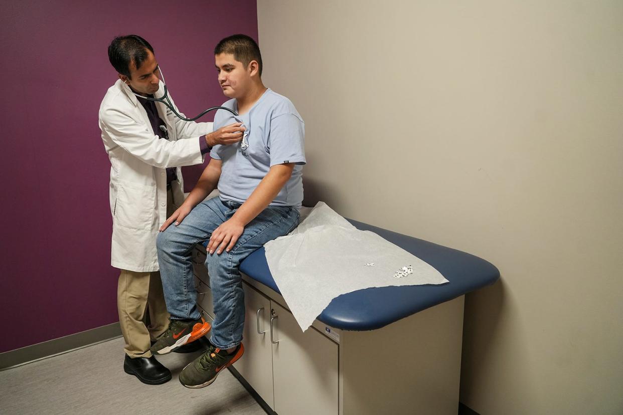 Pediatric cardiology physician Dr. Hitesh Agrawal listens to Juan Amador's heart during his visit at Dell Children's Medical Center Specialty Pavilion on May 30. Juan, 13, had a stroke in April.