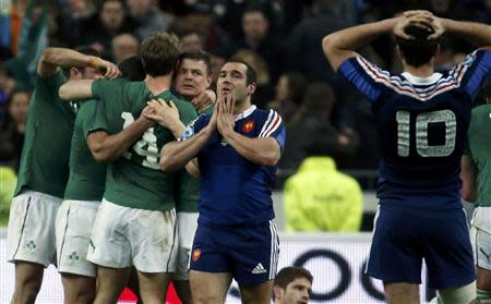 Ireland's Brian O'Driscoll celebrates victory with teammates as France's players Jean Marc Doussain (C) and Remi Tales (R) react at the end of their Six Nations rugby union match at the Stade de France in Saint-Denis, near Paris, March 15, 2014. REUTERS/Benoit Tessier