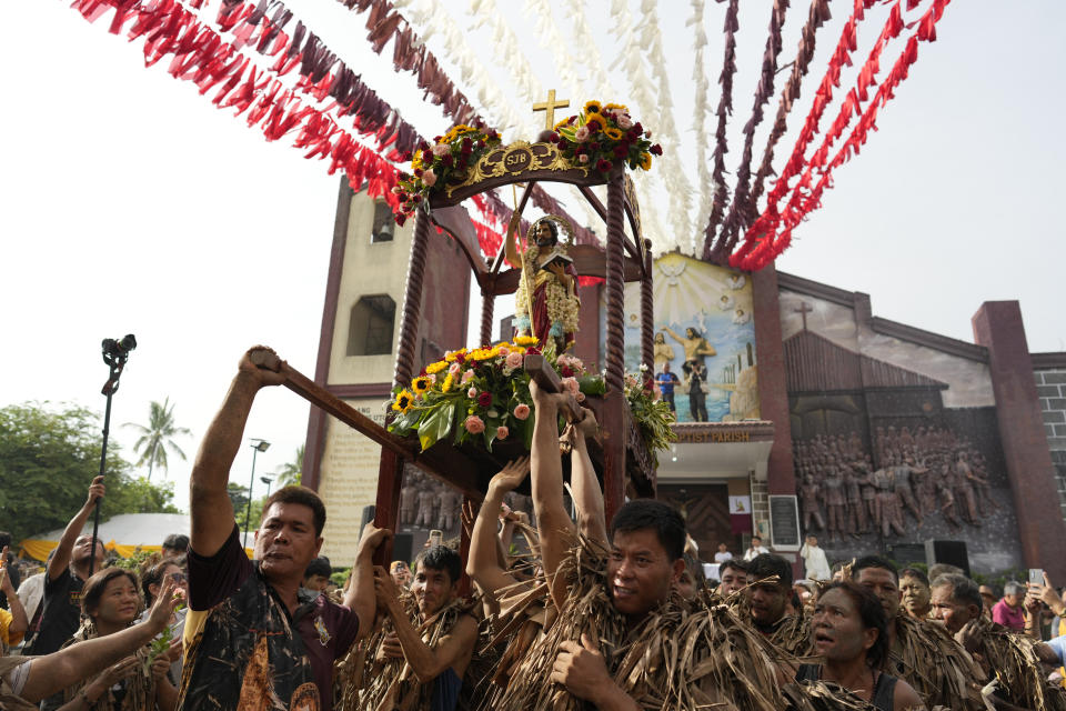 Devout Catholics carry a statue of Saint John the Baptist during the mud festival at Bibiclat, Nueva Ecija province, northern Philippines, Monday, June 24, 2024. (AP Photo/Aaron Favila)