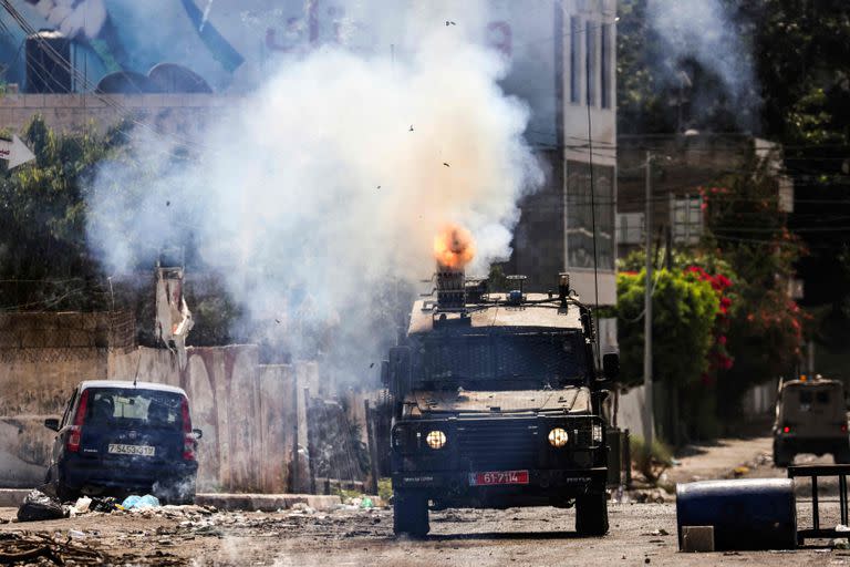 Un vehículo blindado israelí dispara gas lacrimógeno durante una operación militar en curso en la ciudad de Yenín en Cisjordania ocupada el 4 de julio de 2023. 