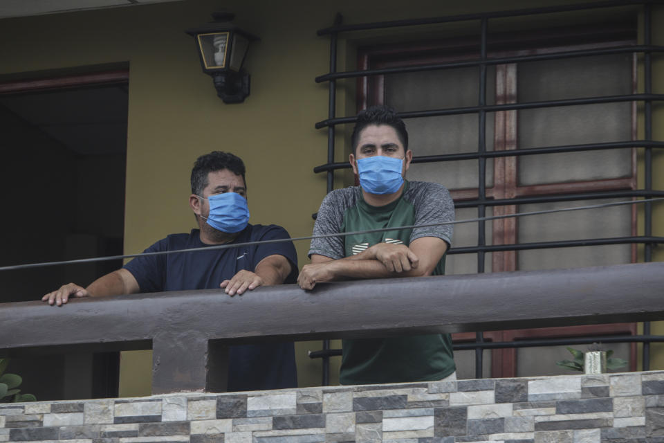 Norman Cardoze, a la izquierda, y su hijo Norman Cardoze Jr. posan para una foto desde el balcón de su casa donde están en cuarentena después de contraer el nuevo coronavirus en Managua, Nicaragua, el miércoles 27 de mayo de 2020. Durante un juego el 16 de mayo el manager Norman Cardoze y el entrenador Carlos Aranda se sintieron enfermos. El hijo de Cardoze, bateador estrella del equipo, estaba tan débil y dolorido que no jugó. En dos días los tres hombres fueron hospitalizados y Aranda murió de coronavirus. (AP Foto/Alfredo Zuniga)