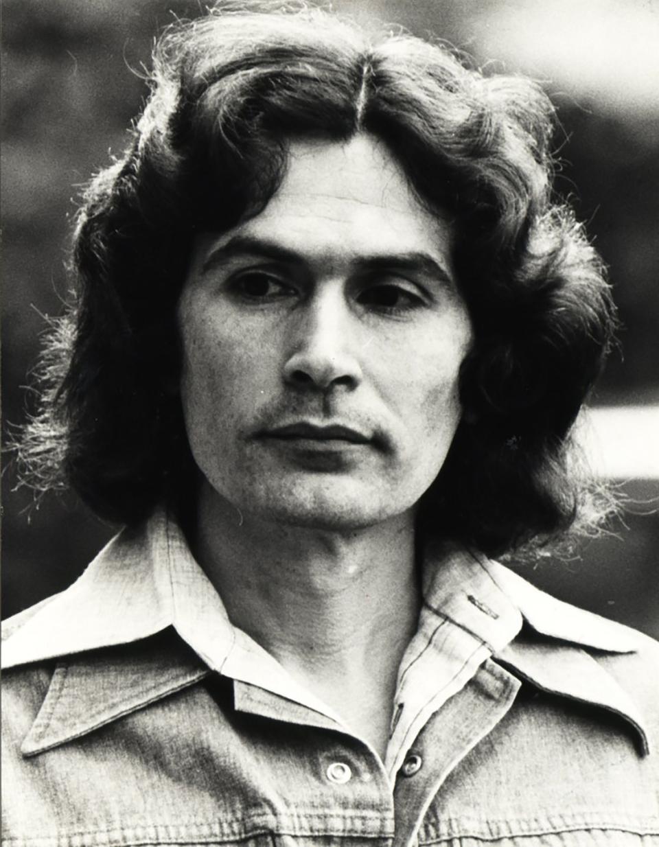 rodney alcala wearing a denim jacket and looking out of frame in a black and white photo