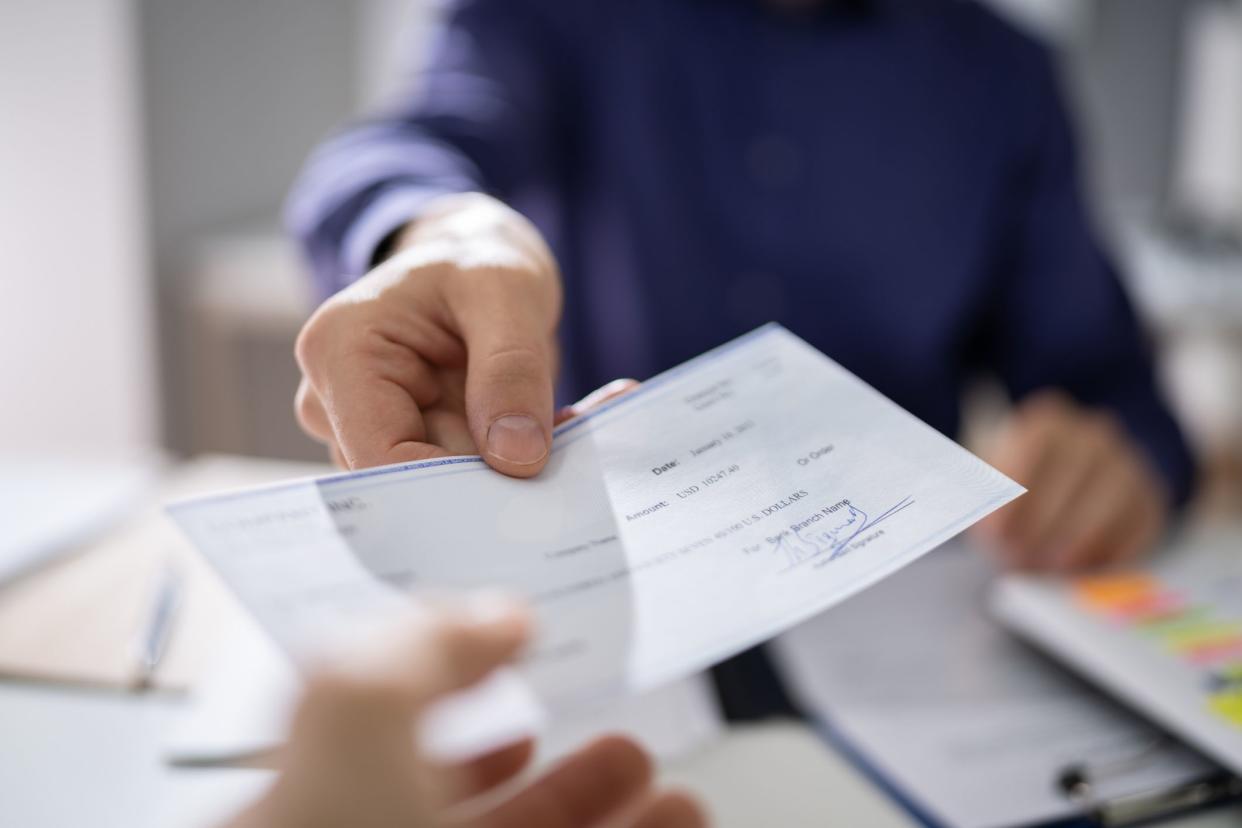 Businessperson Hands Giving Cheque To Other Person