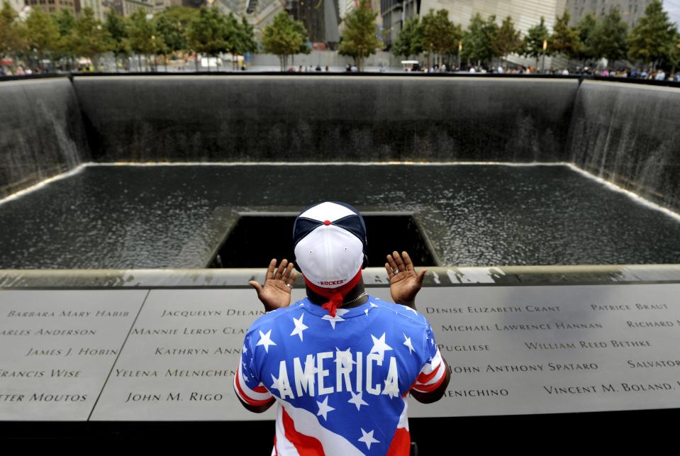 Albert Biatta, of Queens, New York, prays while standing in front of the inscribed name of his uncle Antoine Biatta at the edge of the North Pool during memorial observances held at the site of the World Trade Center in New York, September 11, 2014. (REUTERS/Justin Lane/Pool)