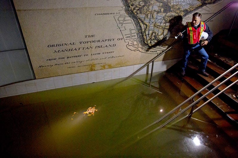 In this Wednesday, Oct. 31, 2012 file photo, Joseph Leader, Metropolitan Transportation Authority vice president and chief maintenance officer, shines a flashlight on standing water inside the South Ferry 1 train station in New York in the wake of Superstorm Sandy.