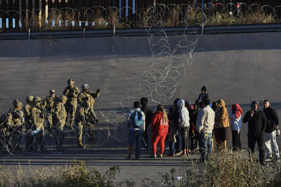 U.S. military stop migrants from crossing into El Paso, Texas, seen from Ciudad Juarez, Mexico, Tuesday, Dec. 20, 2022. The U.S. Supreme Court issued a temporary order to keep pandemic-era limits on asylum-seekers in place, though it could be brief, as conservative-leaning states push to maintain a measure that allows officials to expel many but not all asylum-seekers. (AP Photo/Christian Chavez)