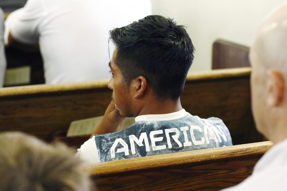 A Latino youth wears a t-shirt that has "American" written on the back at a Spanish Mass at Sacred Heart Catholic Church in Canton, Miss., Sunday, Aug. 11, 2019. Churches have been key to providing spiritual and emotional comfort to workers following immigration raids at seven Mississippi poultry plants, and are now stepping up to provide material aid to jailed or out-of-work church members, even as some church leaders denounce the raids that Republican leaders of the conservative state have applauded. (AP Photo/Rogelio V. Solis)