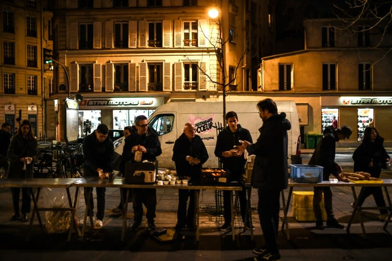 Des bénévoles des "Restos du coeur" mettent en place un point de distribution alimentaire, à Paris le 21 mars 2023 (Christophe ARCHAMBAULT)