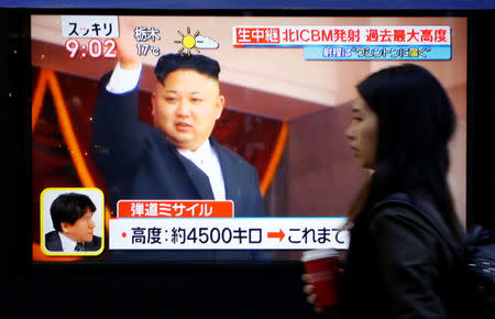 A woman walks past a street monitor showing North Korea's leader Kim Jong Un in a news report about North Korea's missile launch, in Tokyo, Japan, November 29, 2017. REUTERS/Toru Hanai