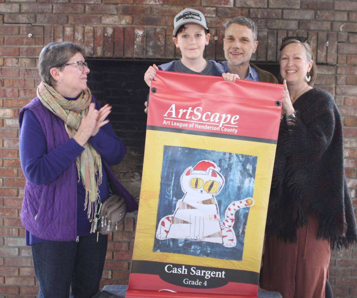 Fourth grader Cash Sargent poses with his banner and his family at the reveal event held last week at Jackson Park.