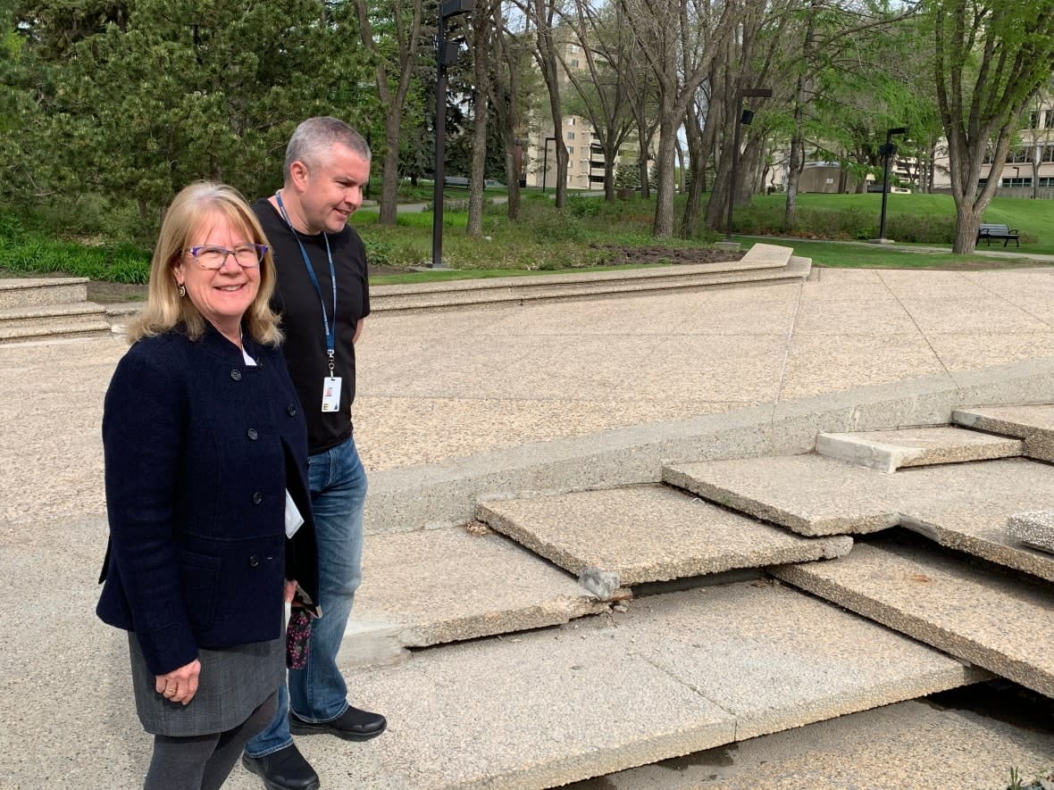 Cathy Saar-Paradis, director of project delivery for Alberta Infrastructure, and Dale Beesley, assistant deputy minister of the ministry's properties division, stand beside the tiled wading pools on the grounds of the Alberta legislature. The province wants to demolish this feature and build something that would be safe for children to use.  (Michelle Bellefontaine/CBC  - image credit)