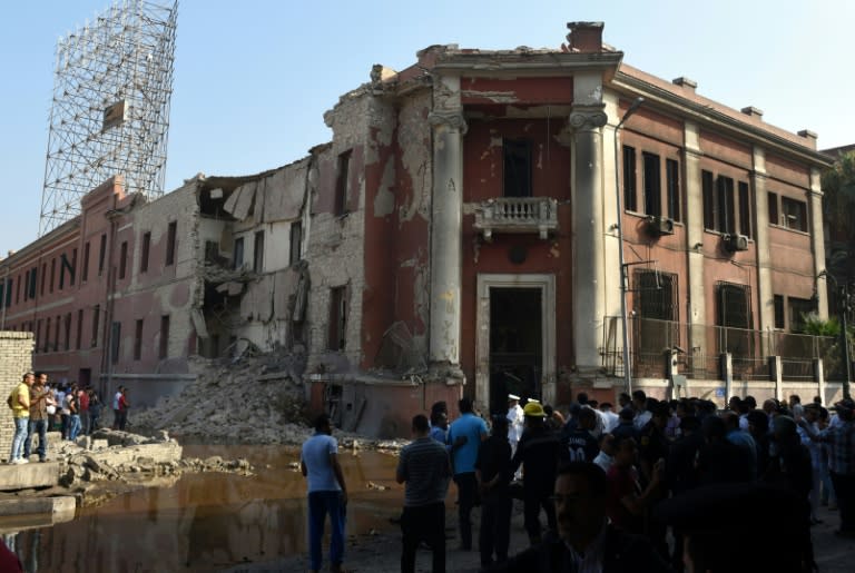 Egyptian security and civilians look at the the destroyed facade of the Italian consulate in Cairo, on July 11, 2015