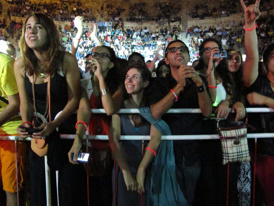 FILE - In this Friday, Sept. 14, 2012 file photo, Arab fans of the Lebanese group Mashrou Leila' cheer as the band performs in the ancient Roman amphitheater in the Jordanian capital Amman. A Lebanese band that supports gay rights has found itself at the center of a heated debate in Lebanon about freedom of expression. Church leaders and conservative politicians demand that a concert by Mashrou' Leila in the coastal city of Byblos be canceled, setting off a storm of indignation on social media. (AP Photo/Diaa Hadid, File)