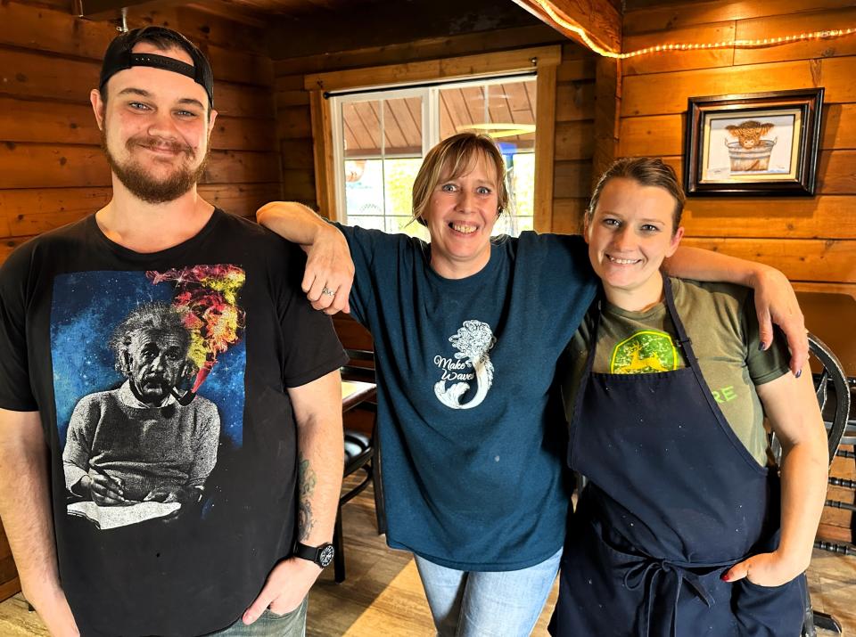 Roadrunner Grill employees Jason Coon, left, and Kristen Wampler, right, pose with owner Robin Evans, center, inside their Cascade Boulevard location.