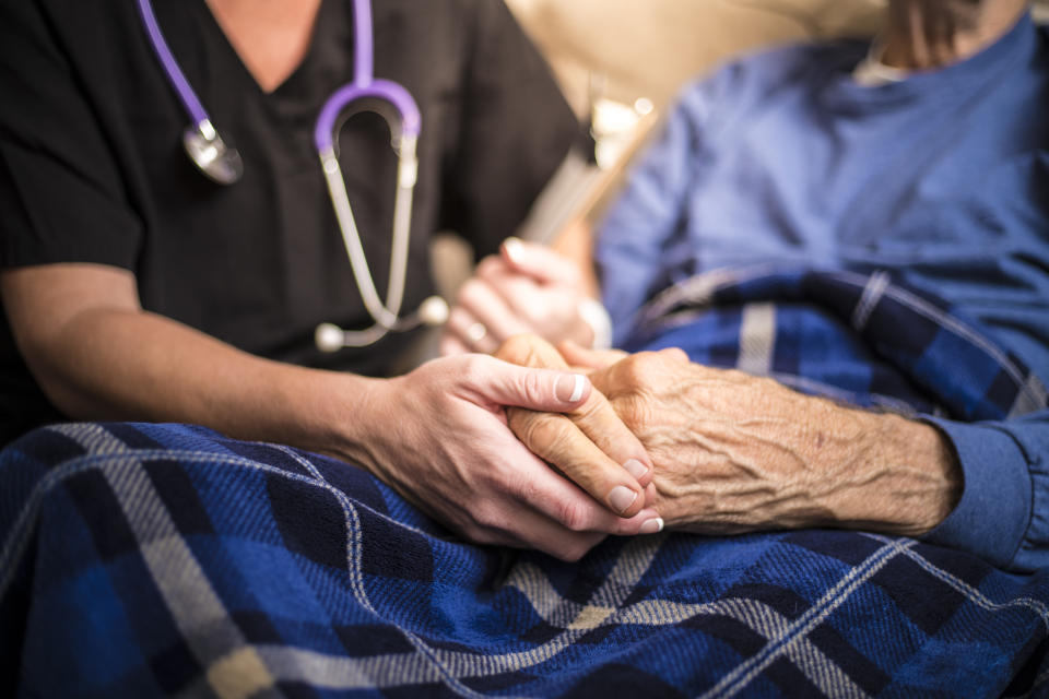 A stock photo of a Hospice Nurse visiting an Elderly male patient who is receiving hospice/palliative care.