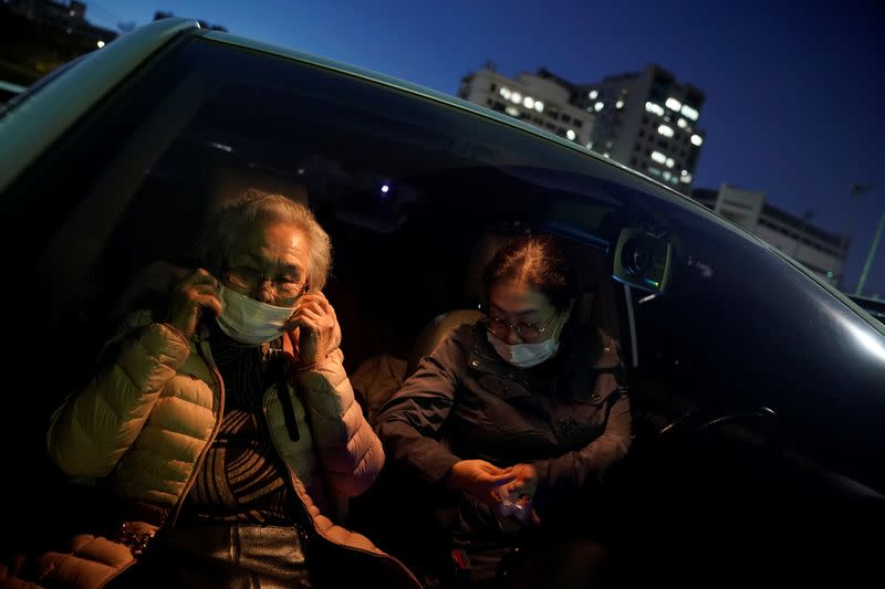 An elderly woman adjusts her mask as she waits for a movie to start at a drive-in theatre that has been temporarily made for residents to enjoy movies while keeping social distancing following the outbreak of the coronavirus disease (COVID-19), in Seoul