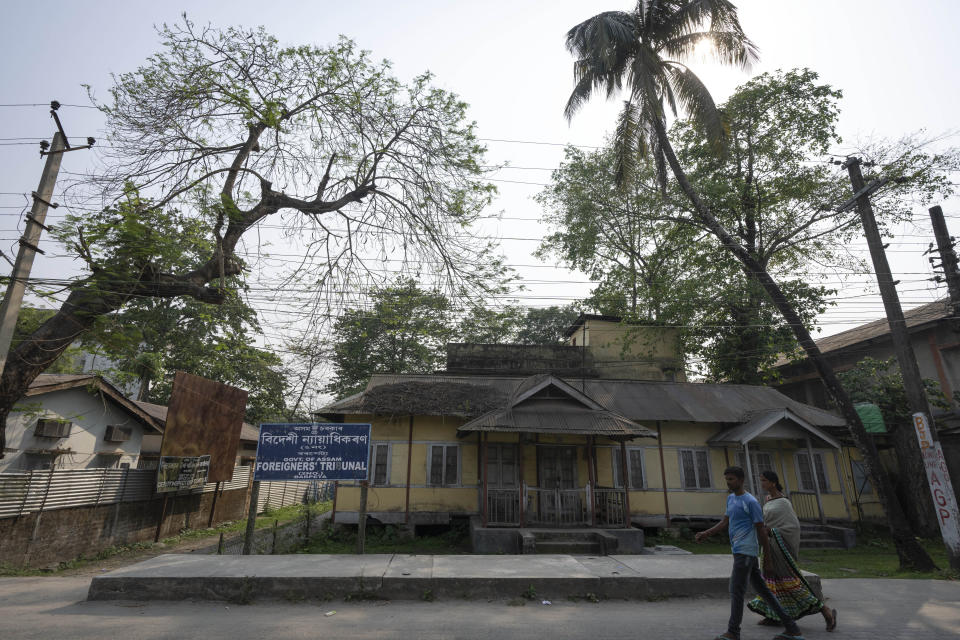 A man and a woman walk past foreigners tribunal office in Barpeta, north eastern Assam state, India, April 16, 2023. Nearly 2 million people, or over 5% of Assam's population, could be stripped of their citizenship unless they have documents dating back to 1971 that show their ancestors entered the country legally from neighboring Bangladesh. Many believe Assam is overrun with immigrants from Bangladesh, and hundreds have been put in detention centers unable to produce documents to prove they're Indian. (AP Photo/Anupam Nath)