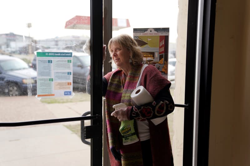 McAnally sanitizes the front door at the Farmers Public Market in Oklahoma City