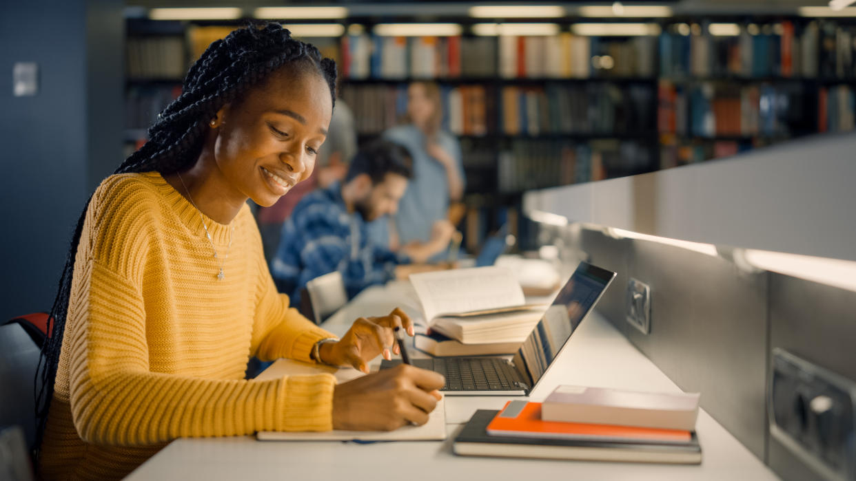  Student uses Laptop, Writes Notes for the Paper. 