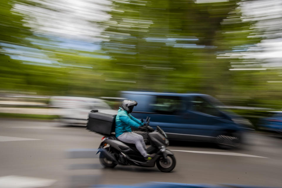 A delivery worker rides his motorbike in Madrid, Spain, Tuesday, May 11, 2021. Spain has approved a pioneering law that gives delivery platforms a mid-August deadline to hire the workers currently freelancing for them and that requires transparency of artificial intelligence to manage workforces. (AP Photo/Manu Fernandez)