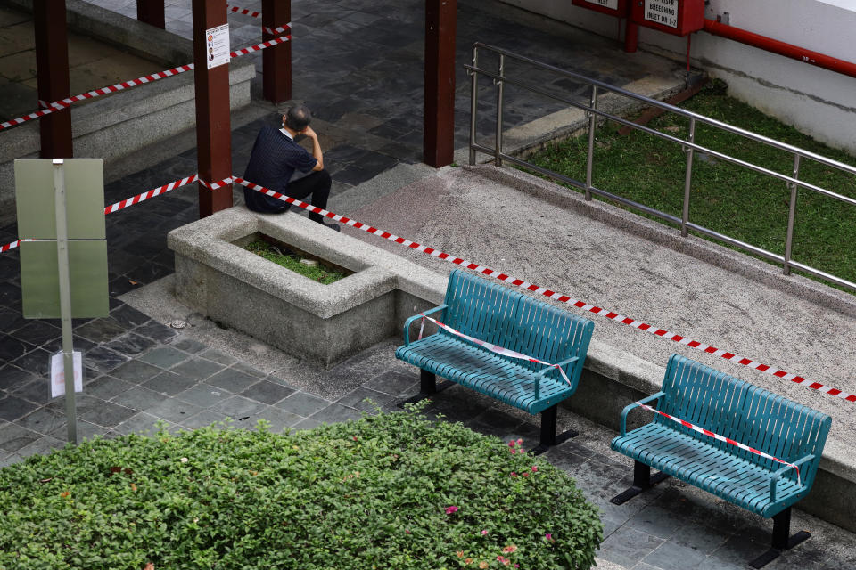 A man sits at the edge of a cordoned off seating area to prevent overcrowding on June 19, 2021 in Singapore. On June 14, Singapore began to ease restriction in stages as local community COVID-19 cases remain under control. Social gathering group size limit were increased from 2 to 5 persons, while dining-in at food establishment is still prohibited until June 21. Work from home remains the default arrangement. (Photo by Suhaimi Abdullah/NurPhoto via Getty Images)