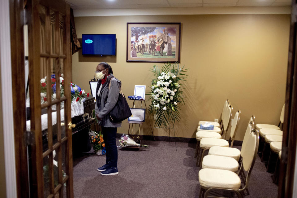 Flint resident Pam Jones, a childhood friend, says her goodbye while wearing a mask during the visitation service for Calvin Munerlyn on Friday, May 8, 2020 at Sheldon T. Banks Funeral Chapel in Flint, Mich. Munerlyn, 43, of Flint was shot at the Family Dollar store following an alleged verbal altercation with 45-year-old Sharmel Teague after he told the woman's daughter she needed to wear a mask while inside. (Jake May/The Flint Journal, MLive.com via AP)