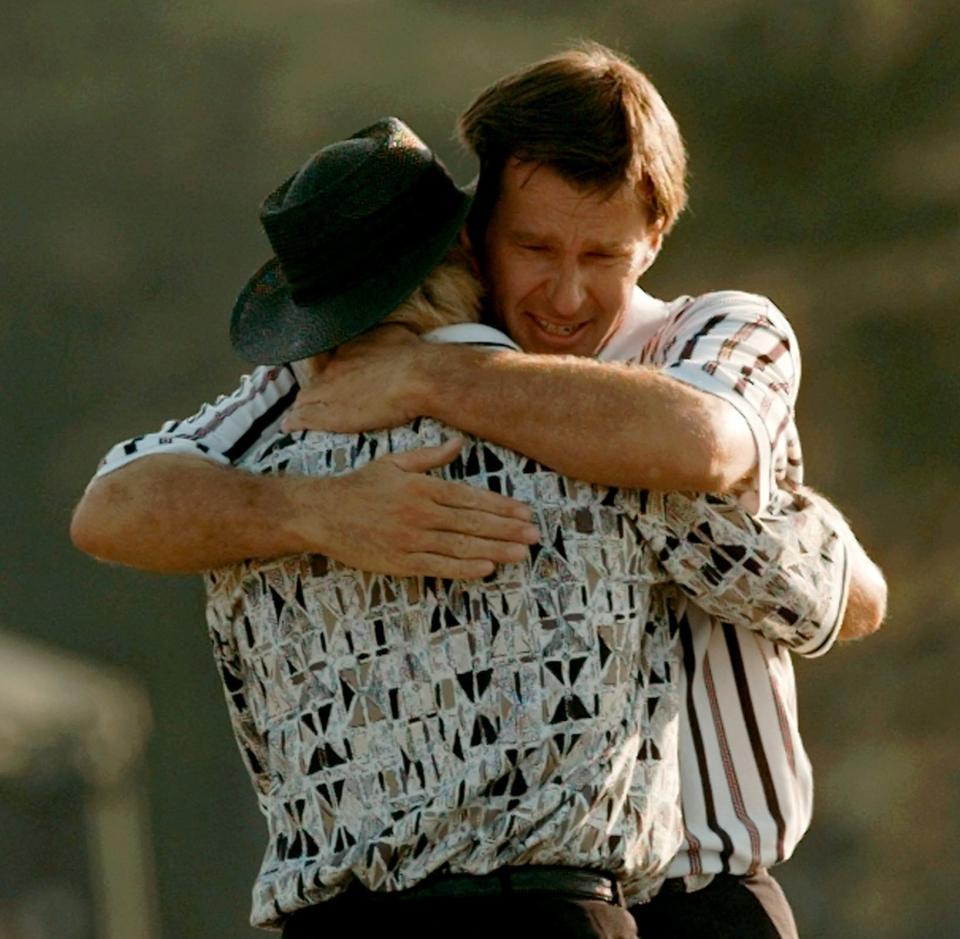 FILE - In this April 14, 1996, file photo, Nick Faldo hugs Greg Norman, left, as they finish up on the 18th hole of the Masters golf tournament at Augusta National Golf Club in Augusta, Ga. Faldo came from behind to beat Norman by five strokes to win his third Masters. (AP Photo/Dave Martin, File)