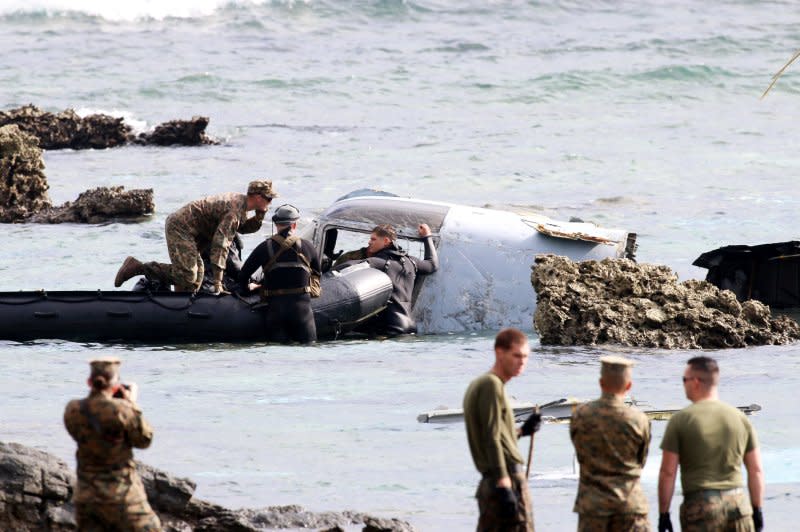 U.S. military personnel inspect the wreckage of the tiltrotor MV-22 Osprey aircraft that crash landed in the sea on December 13, 2016 off the coast of Nago, Okinawa Island, Japan. File Photo by Hitoshi Maeshiro/EPA
