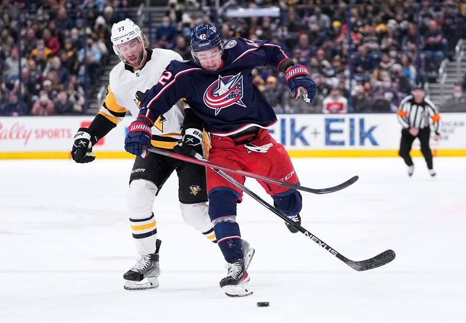 Columbus Blue Jackets center Alexandre Texier (42) skates around Pittsburgh Penguins center Jeff Carter (77) during the first period of the NHL hockey game at Nationwide Arena in Columbus on Friday, Jan. 21, 2022. 