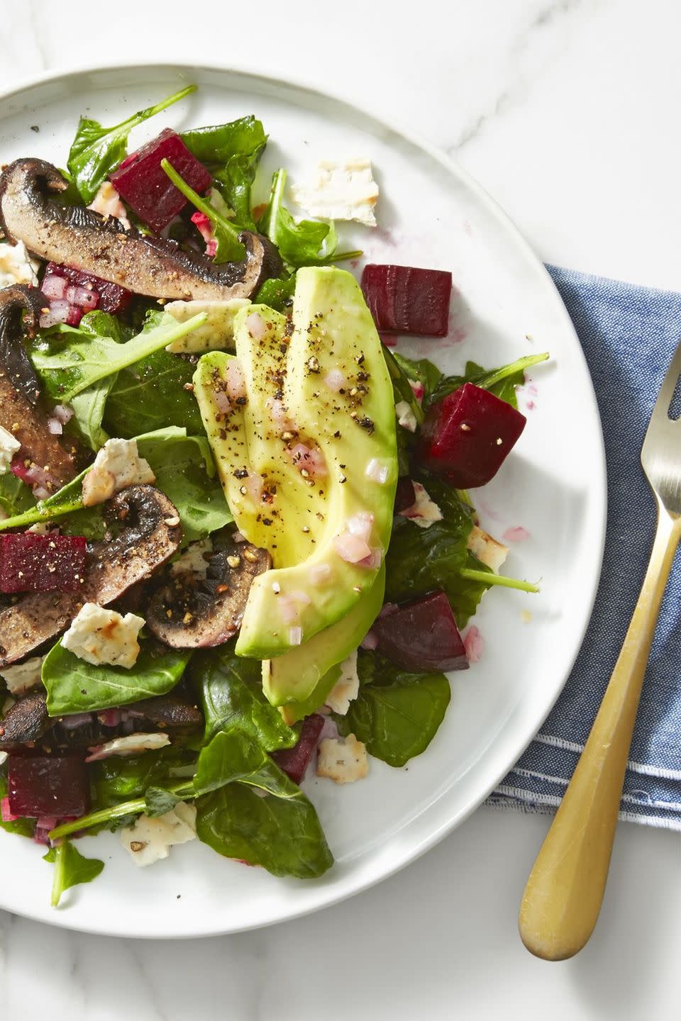 beet, mushroom and avocado salad on a white plate