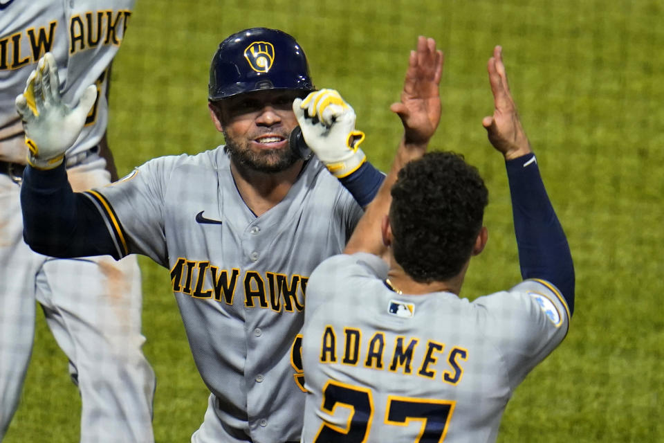 Milwaukee Brewers' Manny Pina, left, celebrates with Willy Adames (27) after hitting a two-run home run off Pittsburgh Pirates relief pitcher Austin Davis during the eighth inning of a baseball game in Pittsburgh, Thursday, July 29, 2021. (AP Photo/Gene J. Puskar)