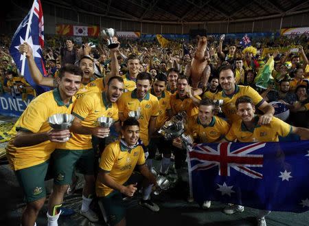 Australia's players pose for pictures with their medals and the Asian Cup trophy after they beat South Korea to win the tournament at the Stadium Australia in Sydney January 31, 2015. REUTERS/Tim Wimborne