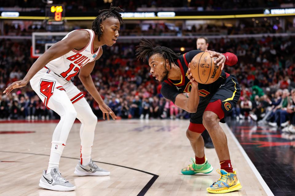 Chicago Bulls guard Ayo Dosunmu, left, defends against Cleveland Cavaliers guard Darius Garland, right, during the first half of an NBA basketball game, Saturday, March 12, 2022, in Chicago. (AP Photo/Kamil Krzaczynski)