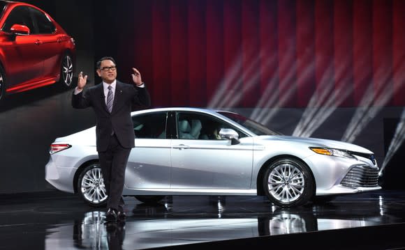 Toyoda is shown on stage presenting an all-new Camry sedan at the 2017 North American International Auto Show.
