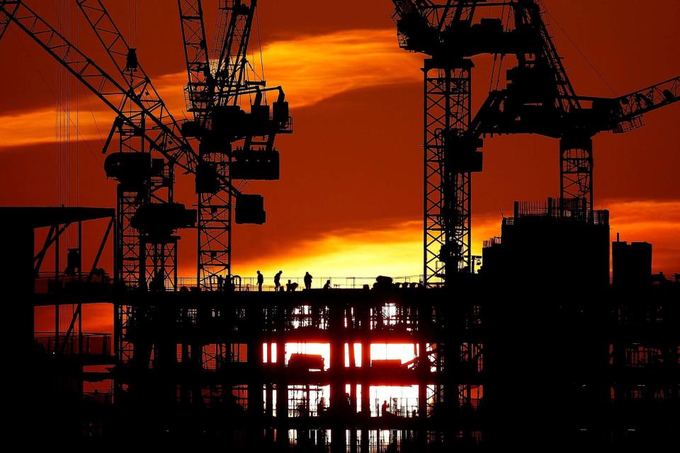 Workers are seen as the sun sets behind a construction site in London, Britain, January 21, 2020: REUTERS