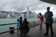 People stand by the shore as the Hong Kong Observatory raised its No.8 storm warning, in Hong Kong, Saturday, July 2, 2022. Typhoon Chaba is buffeting Hong Kong, bringing high winds and plenty of rain, but no serious damage, as of midday Saturday. (AP Photo/Kin Cheung)