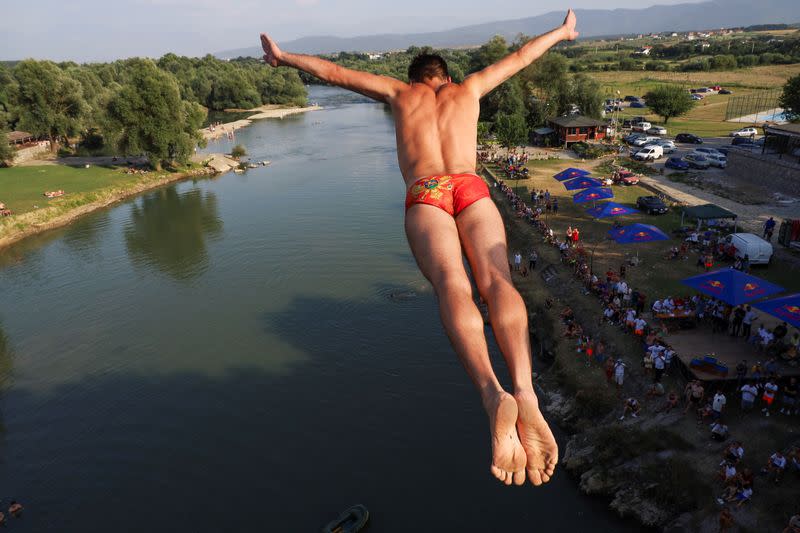 Divers jump into a river from a bridge in Kosovo