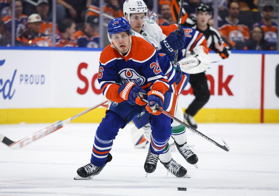 Vancouver Canucks forward Lane Pederson, right, chases Edmonton Oilers forward Mattias Janmark during second-period NHL hockey game action in Edmonton, Alberta, Friday, Dec. 23, 2022. (Jeff McIntosh/The Canadian Press via AP)